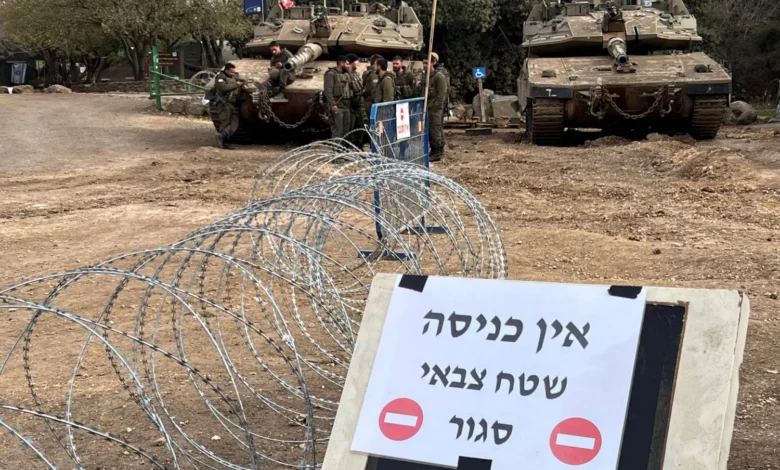 جنود إسرائيليون بجوار دبابتين في مرتفعات الجولان المحتلة بالقرب من الحدود مع سوريا يوم السبت أمام لافتة كتب عليها «ممنوع الدخول. منطقة عسكرية مغلقة» (رويترز)